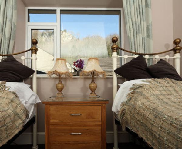 Old Peculier is a quiet and pleasant twin bedded room overlooking Castleberg Crag. The Victorian style beds, contemporary oak furniture and warm cosy soft furnishing provide a relaxing and homely environment.
The room has a first class en-suite with granite tiling and a power shower. Room includes Breakfast.

This room also has a private balcony, exclusive for guests staying in this room – complete with garden furniture chairs to enjoy the glorious Settle Sunshine!