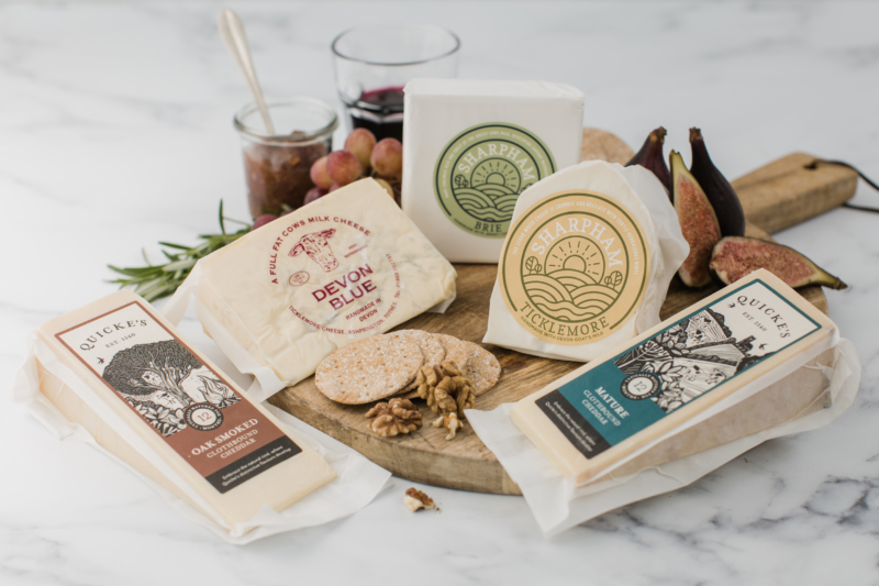 A collaboration between Devon’s finest cheese-makers brings you the Essential Devon Cheese Board featuring five artisan cheeses. Each cheese is made with milk from cows and goats that have grazed Devon’s luscious pastures, crafted with over 100 years of skills and nurtured with love until ready for your cheese board. The essential cheese lover’s box will be delivered to your door with no contact necessary.
Your board includes the Devon classics; Sharpham Brie, Quickes Mature Cheddar and Devon Blue, plus a ‘Grader’s Choice’ from both Sharpham and Quickes, plus a packet of delicious Peters Yard Sourdough Crispbreads.
You will receive five pieces (circa 1.2kg combined) of artisan cheese individually wrapped along with tasting notes for each, all boxed up and ready to go.