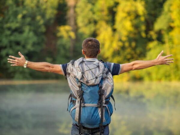Walking For Mental Health A man stood in nature arms stretched as he enjoys the mental helath boost of walking. The Outdoor Guide encourages outdoor activity to increase wellbeing.