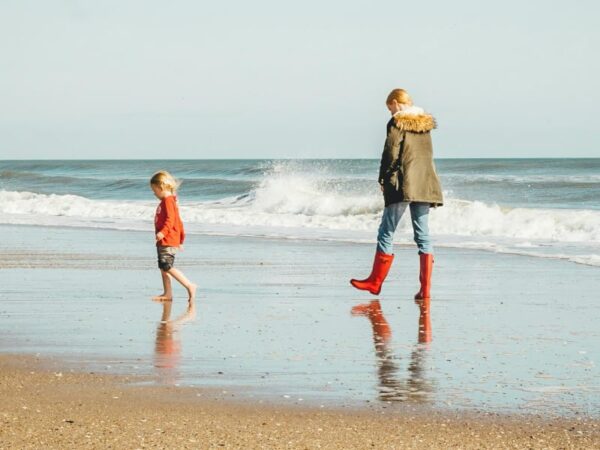 Coastal walking father and son on the beach South West Coastal Path.