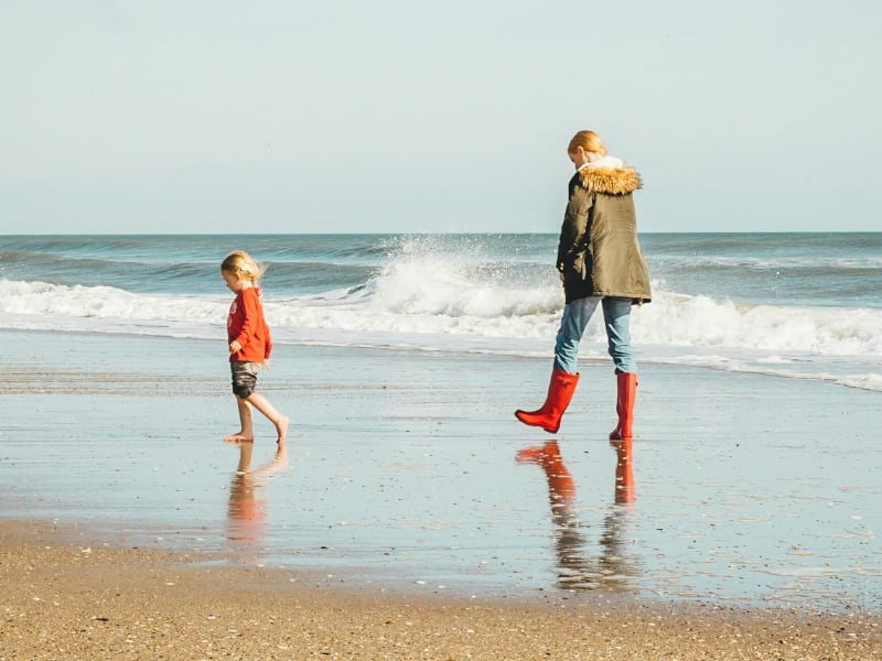 Coastal walking father and son on the beach South West Coastal Path.