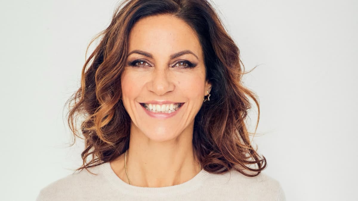 Julia Bradbury in an ecru jumper, smiling for The Outdoor Guide