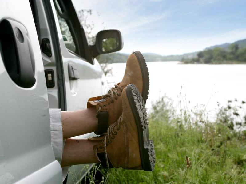 Post-Walk Recovery: Gentle Stretch and Swing Drills to Maintain Joint Mobility. Hiking boots hang out of the van door.